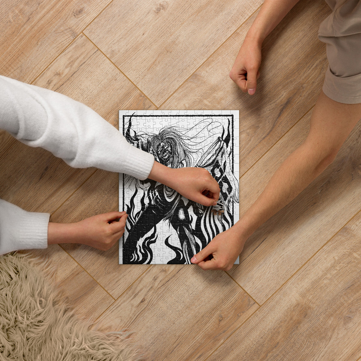 Two people assembling the black-and-white OC Ramps Fulgor jigsaw puzzle on a wooden floor