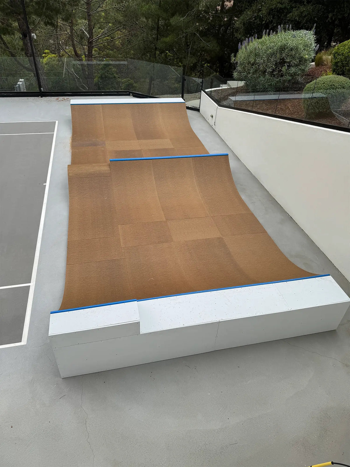 Completed indoor skate bowl with curved wooden half-pipe ramp in Laguna Beach, California.