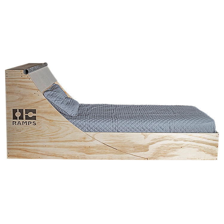 Side view of the wooden OC Ramps Quarter Pipe Bed with curved headboard and bedding
