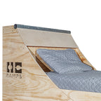 Close view of the Quarter Pipe Bed headboard with metal coping and pillows