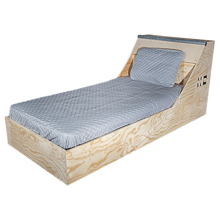 Front three-quarter view of the Quarter Pipe Bed with mattress and grey bedding