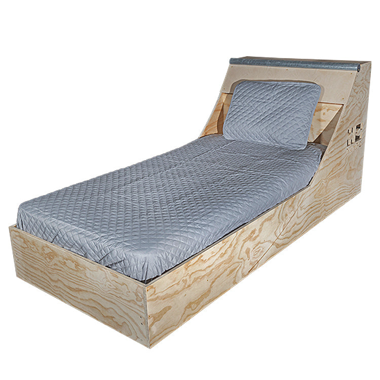 Angled front view of the wooden Quarter Pipe Bed frame with grey bedding