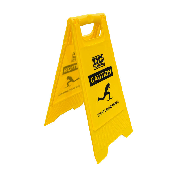 Yellow OC Ramps Caution Skateboarding sign standing open, viewed from an angle