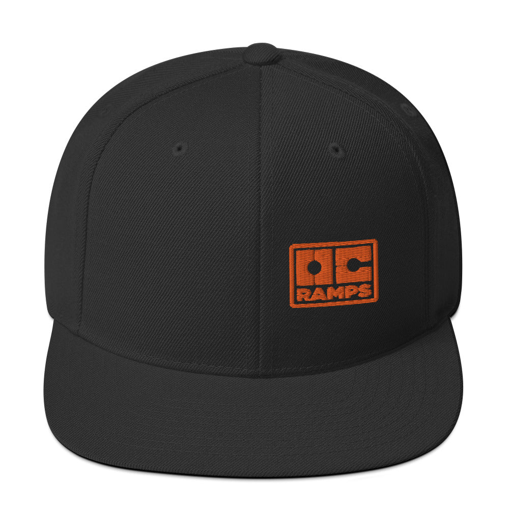 Black flat-brim snapback with an orange OC Ramps logo on the front