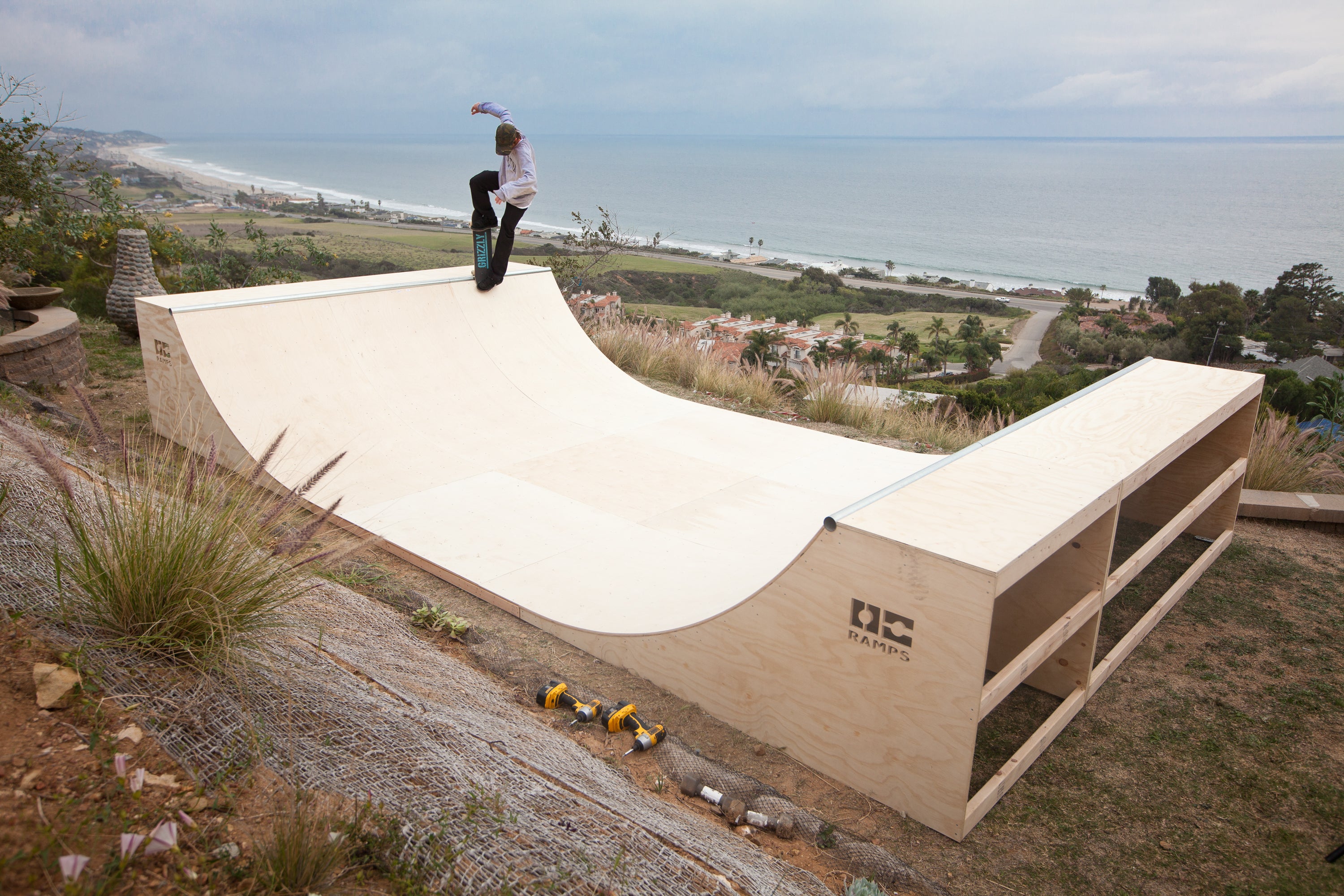 Skateboarder riding an OC Ramps half pipe overlooking the coast